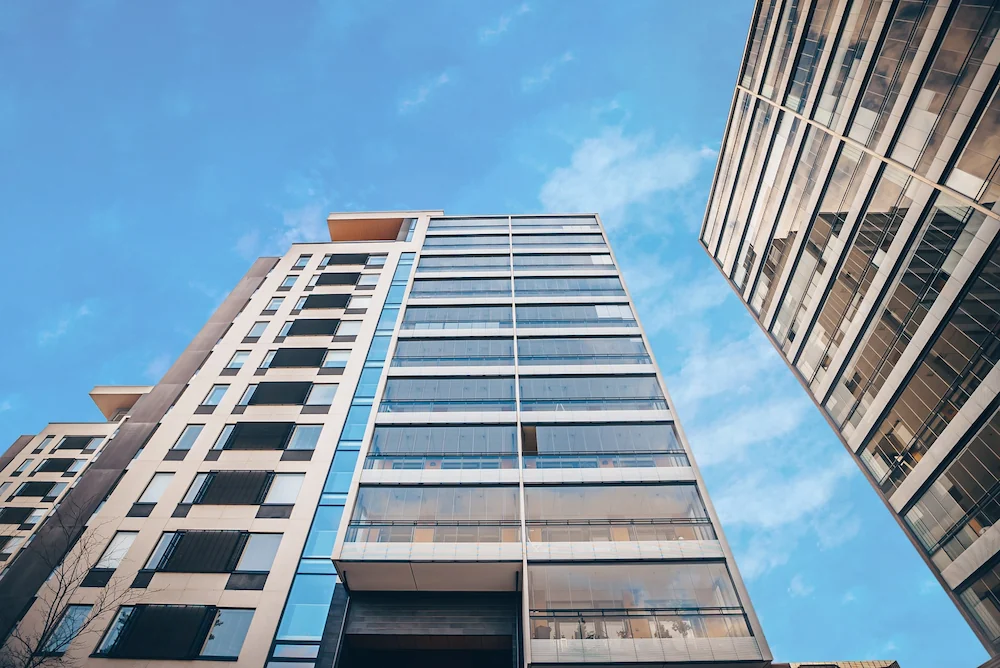 High-rise building with multiple levels of frameless glass walls and integrated railings, enhancing light and modern architecture.