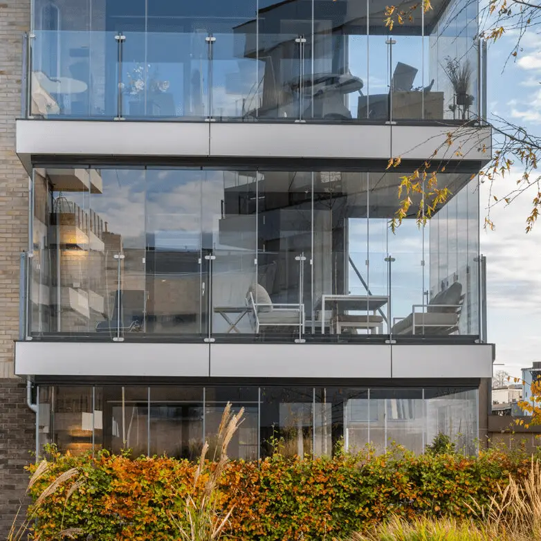 Modern apartment balconies enclosed with integrated glass sunrooms for outdoor living space.