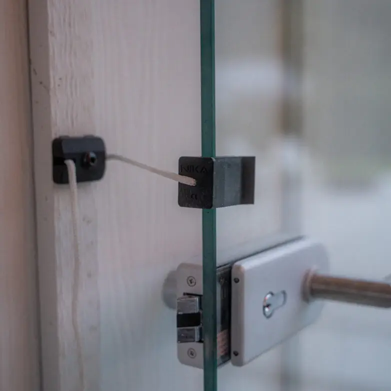 Close-up of secure glass balcony door lock system with safety latch, designed for modern sliding enclosures.